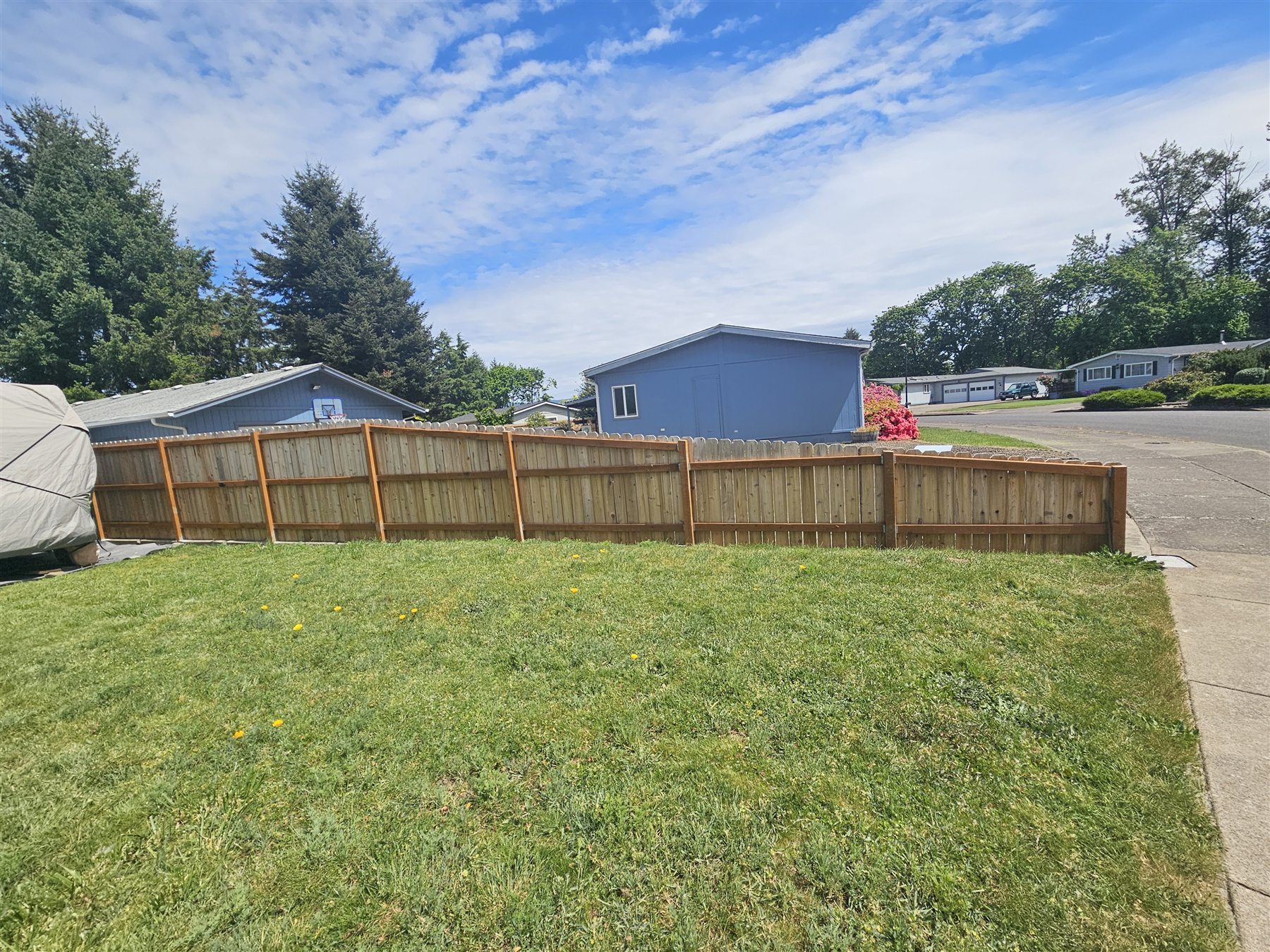 Wood fence building across a wide yard in the Eugene and Springfield service area