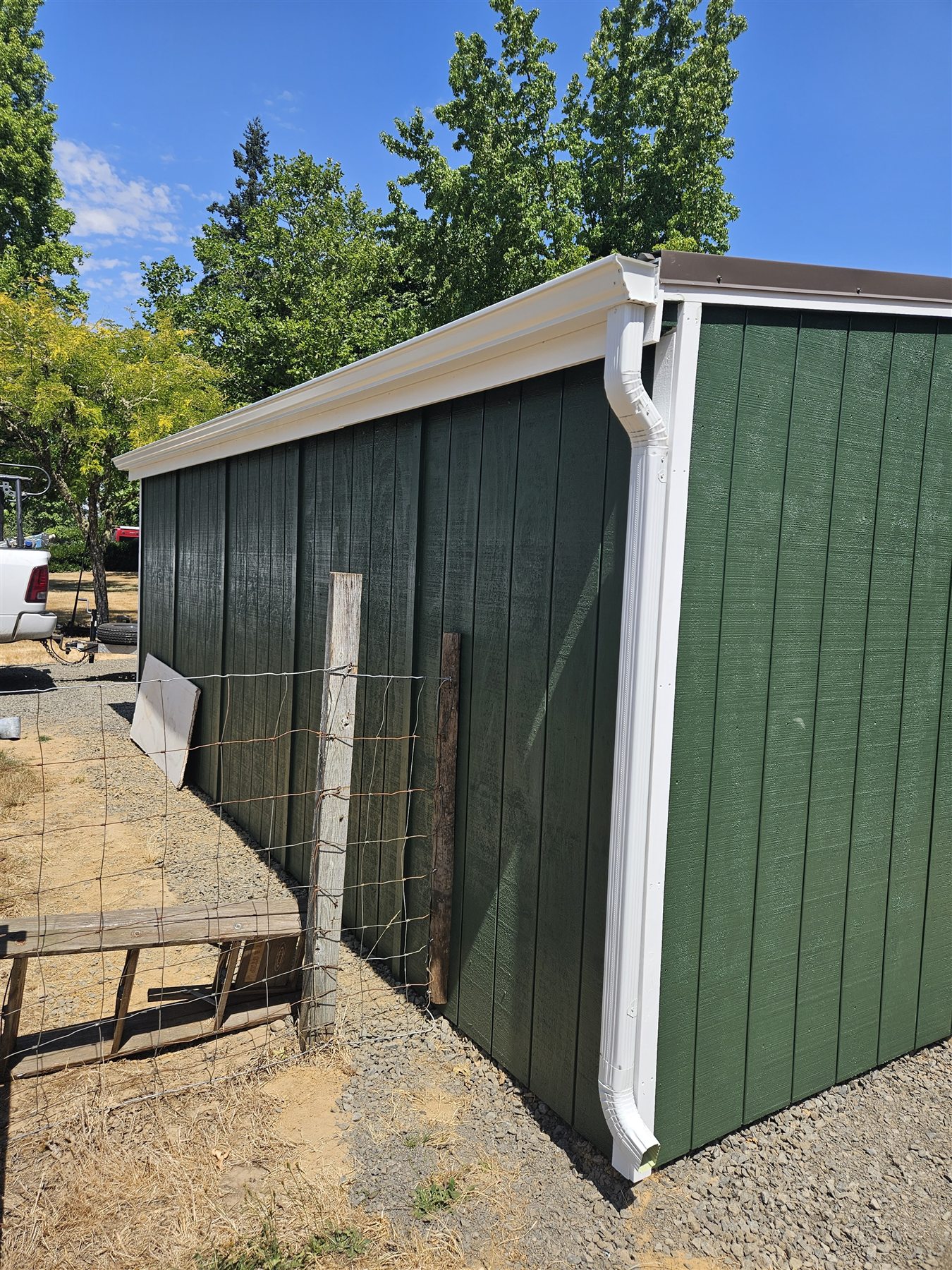 Downspout and gutter installation on a green exterior wall in the Eugene and Springfield service area