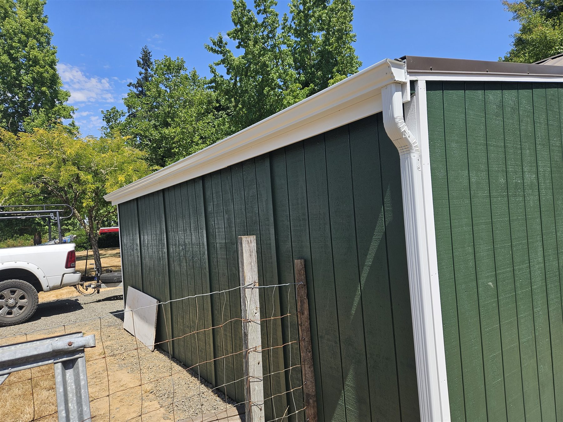 Seamless aluminum gutters on a green outbuilding in the Eugene and Springfield service area